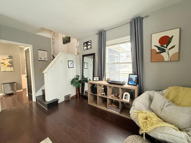 living room featuring baseboards, dark wood finished floors, and stairway