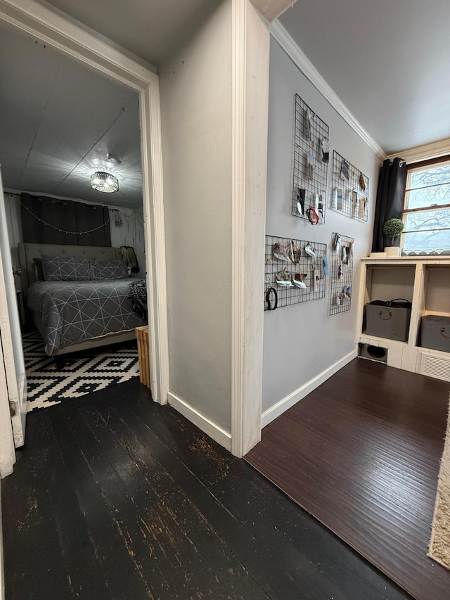 corridor with crown molding, baseboards, and wood finished floors