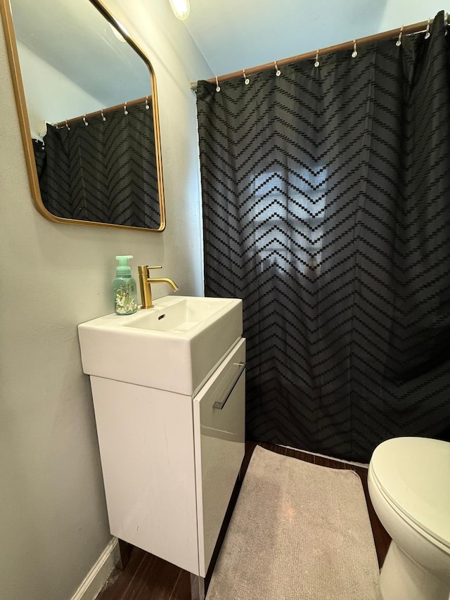 full bath featuring vanity, a shower with curtain, toilet, wood finished floors, and baseboards