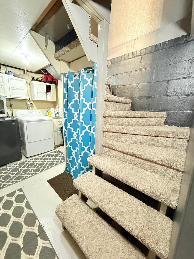stairway featuring washer / clothes dryer, finished concrete flooring, and concrete block wall