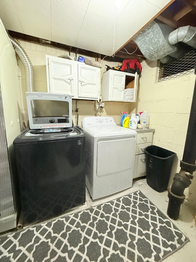 clothes washing area with cabinet space and washer and clothes dryer