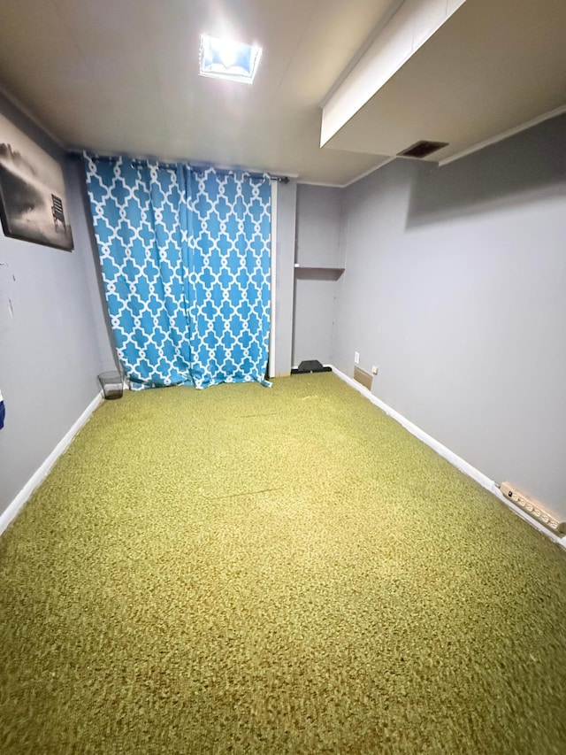 finished below grade area with carpet, visible vents, and baseboards