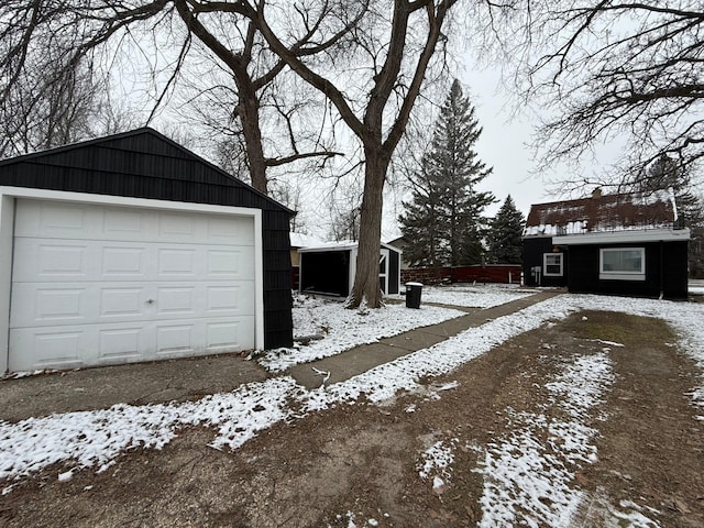snow covered garage with a detached garage