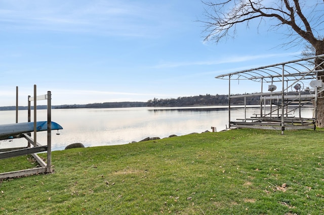 view of dock with a water view, a yard, and boat lift