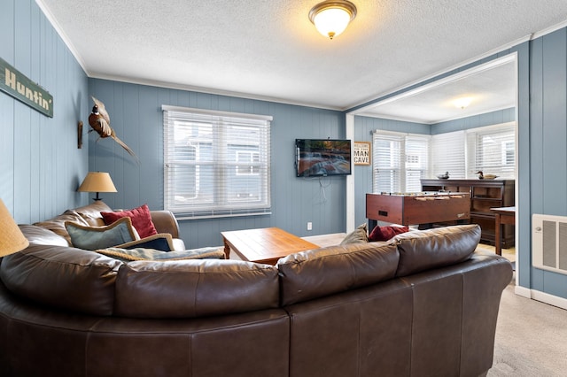 living area featuring plenty of natural light, a textured ceiling, visible vents, and carpet floors