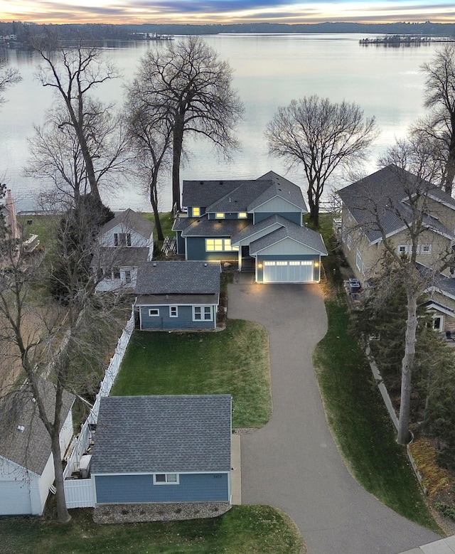 aerial view at dusk featuring a water view