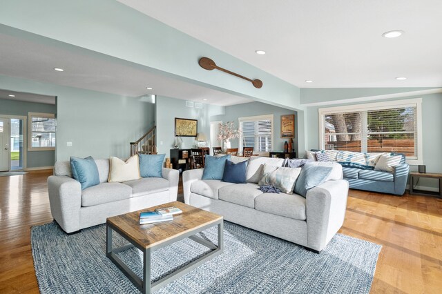 living area featuring recessed lighting, visible vents, wood finished floors, and stairs