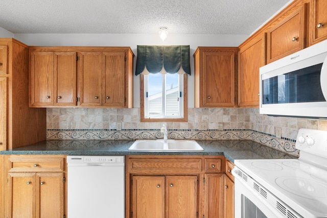 kitchen with a textured ceiling, decorative backsplash, sink, and white appliances