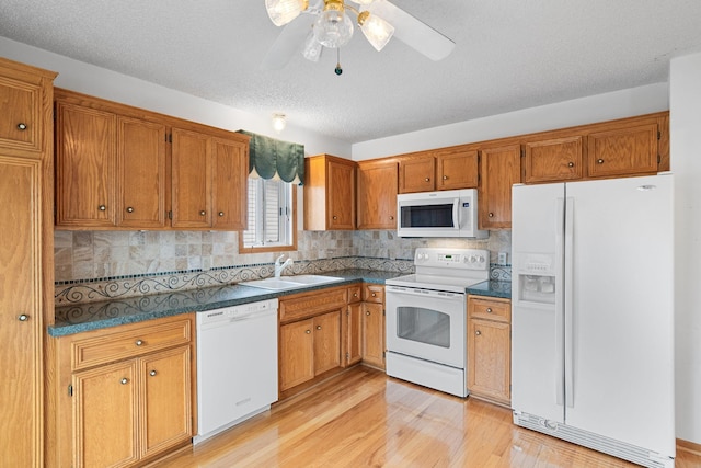 kitchen with a textured ceiling, white appliances, ceiling fan, sink, and light hardwood / wood-style flooring