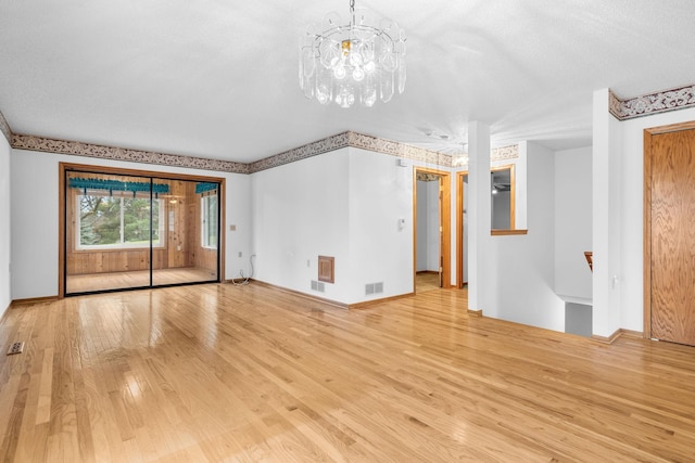 unfurnished living room with light hardwood / wood-style flooring and a textured ceiling