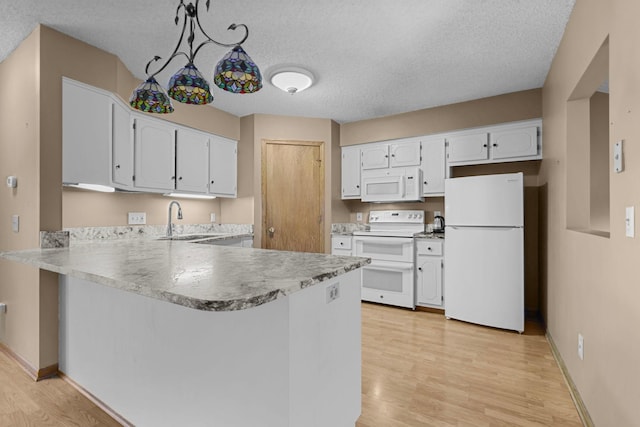 kitchen featuring sink, pendant lighting, white appliances, white cabinets, and light wood-type flooring