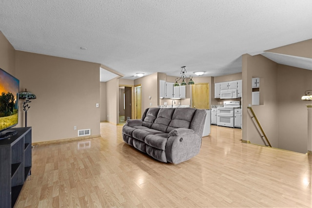 living room featuring a textured ceiling and light wood-type flooring