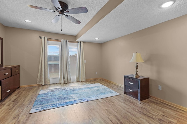 unfurnished room featuring a textured ceiling, light wood-type flooring, and ceiling fan