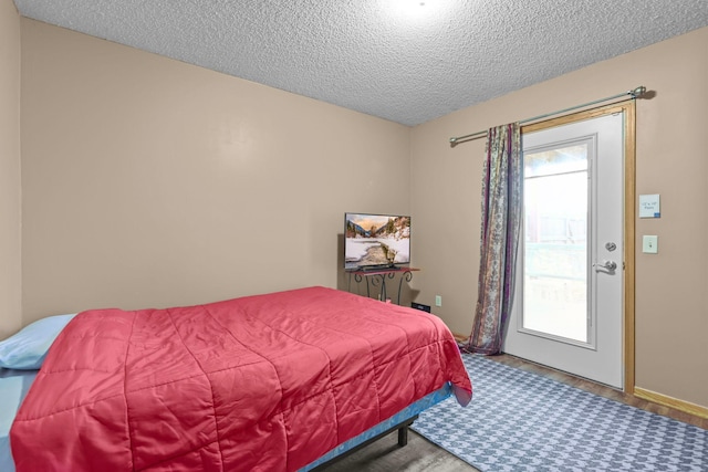 bedroom with a textured ceiling and hardwood / wood-style flooring