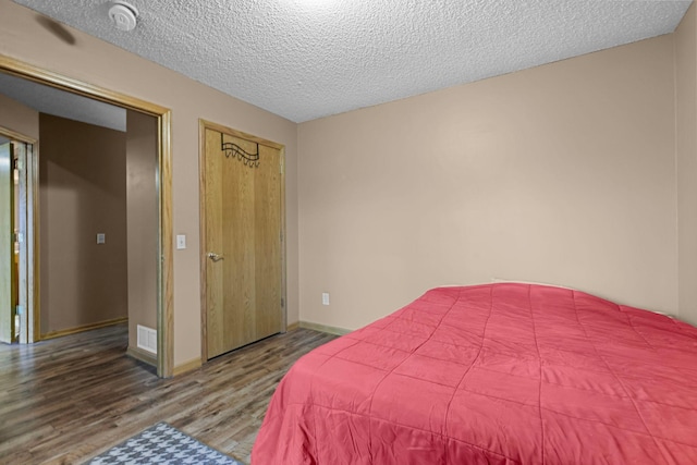 bedroom featuring hardwood / wood-style flooring and a textured ceiling