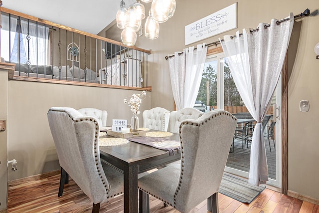 dining room with hardwood / wood-style floors and an inviting chandelier