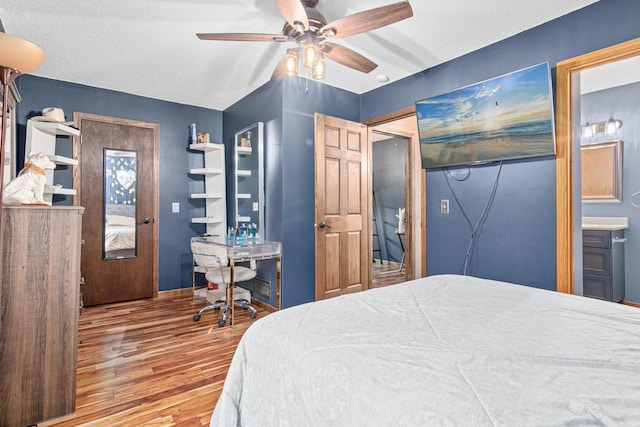 bedroom featuring ensuite bath, ceiling fan, a textured ceiling, and hardwood / wood-style flooring