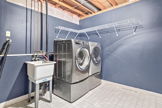 clothes washing area with washing machine and dryer and sink