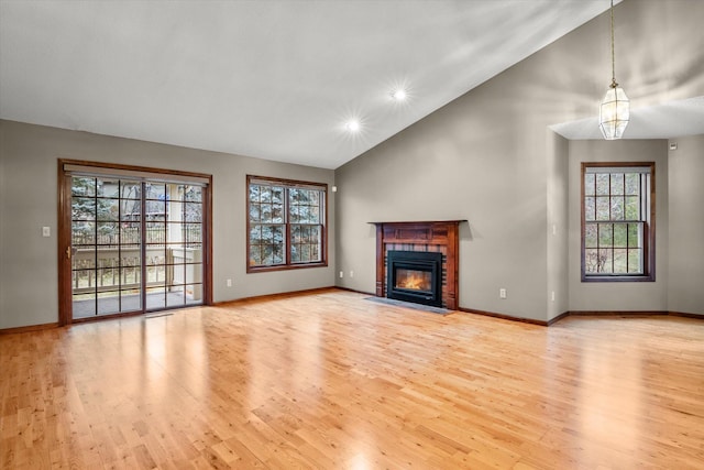 unfurnished living room featuring lofted ceiling, light hardwood / wood-style floors, and a chandelier