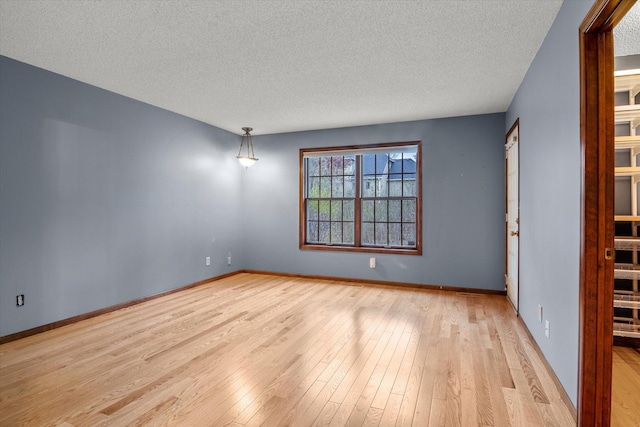 unfurnished room featuring a textured ceiling and light hardwood / wood-style floors