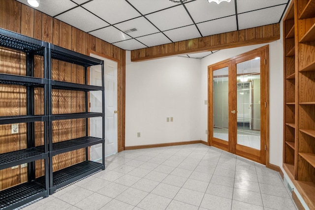 tiled empty room featuring french doors