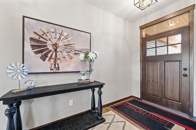 foyer entrance with hardwood / wood-style floors and a textured ceiling