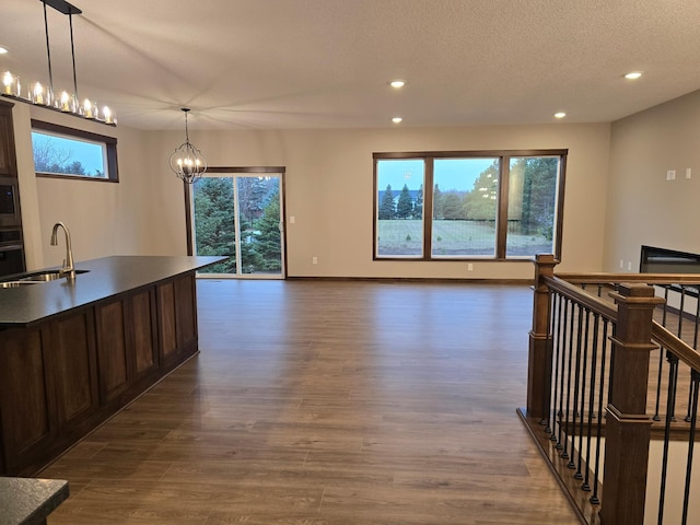 kitchen with sink, hanging light fixtures, wall oven, stainless steel microwave, and dark hardwood / wood-style flooring