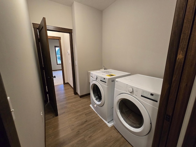 laundry room featuring washing machine and clothes dryer and dark hardwood / wood-style flooring