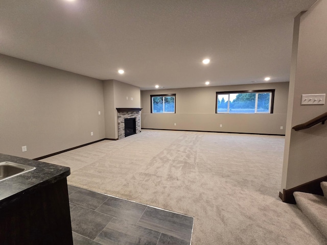 unfurnished living room with dark carpet and a fireplace