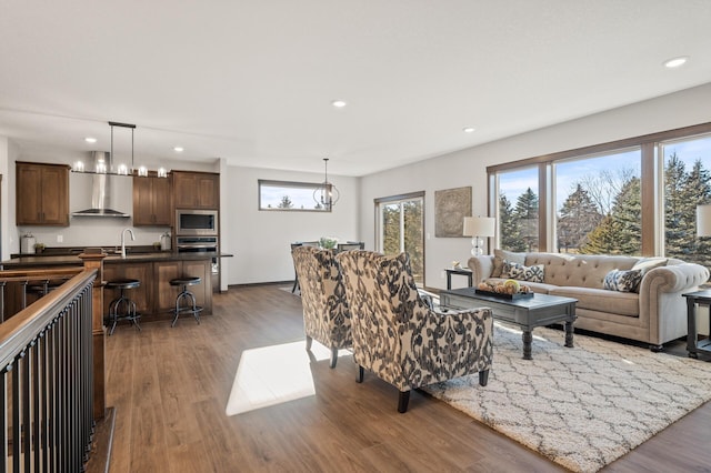 living room featuring dark hardwood / wood-style floors, sink, and a chandelier