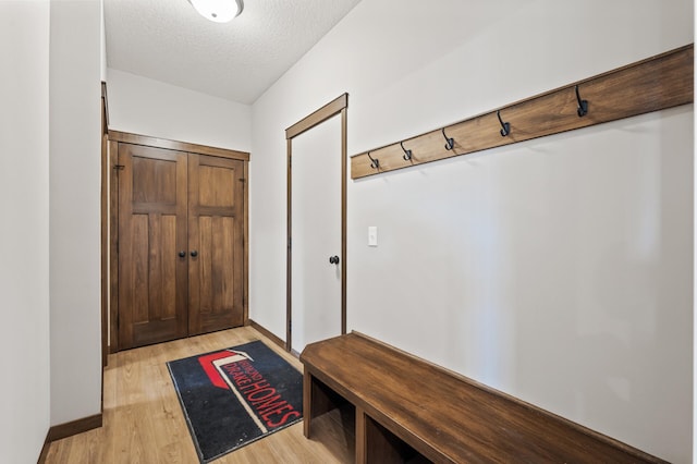 mudroom featuring light hardwood / wood-style flooring and a textured ceiling