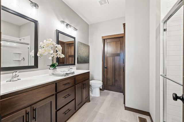 bathroom with walk in shower, vanity, and toilet