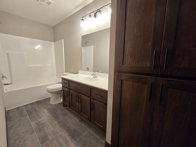 full bathroom featuring vanity, bathtub / shower combination, toilet, and a textured ceiling