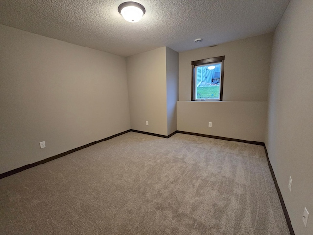 empty room featuring light colored carpet and a textured ceiling