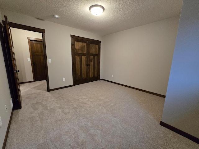 unfurnished bedroom with light colored carpet and a textured ceiling