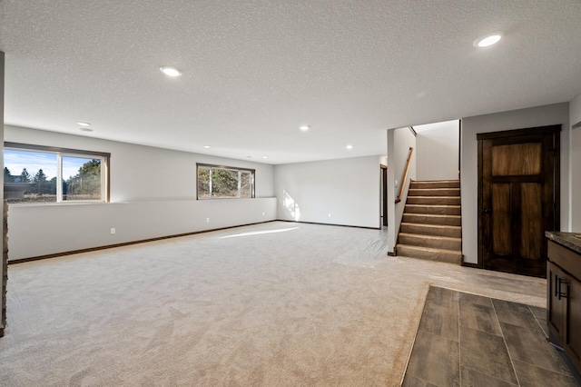 interior space featuring a textured ceiling and carpet