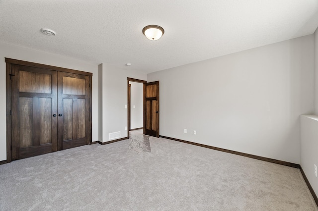 unfurnished bedroom featuring light colored carpet and a closet