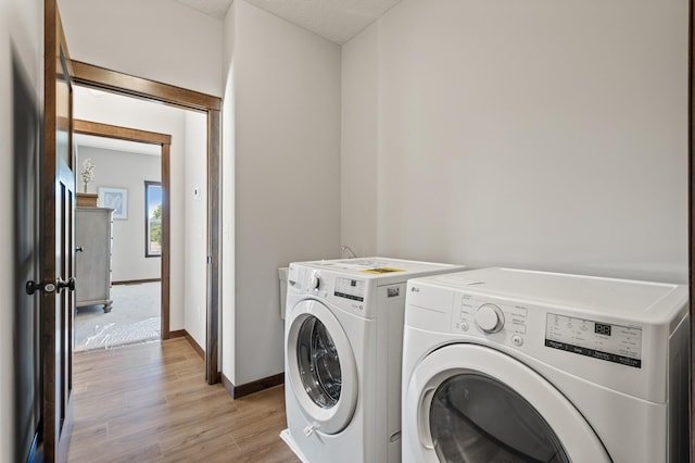 laundry room featuring washer and dryer and light hardwood / wood-style flooring