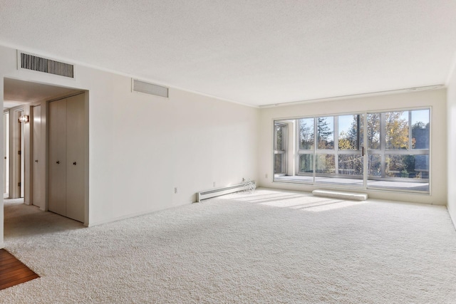 carpeted empty room featuring a baseboard radiator, ornamental molding, and a textured ceiling