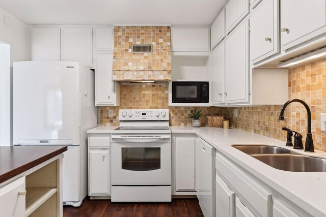 kitchen featuring dark hardwood / wood-style flooring, white appliances, white cabinetry, and sink