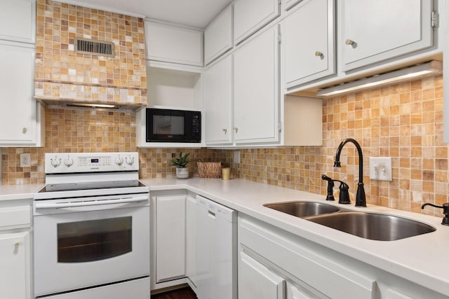 kitchen featuring tasteful backsplash, white appliances, sink, and white cabinets