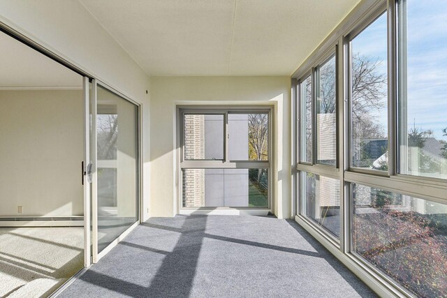 unfurnished sunroom featuring a baseboard heating unit