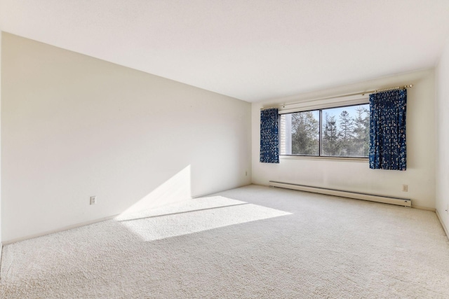 carpeted empty room featuring a baseboard heating unit