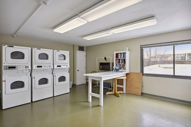 clothes washing area featuring a textured ceiling and stacked washer / dryer