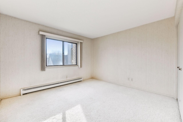 carpeted empty room featuring a baseboard heating unit