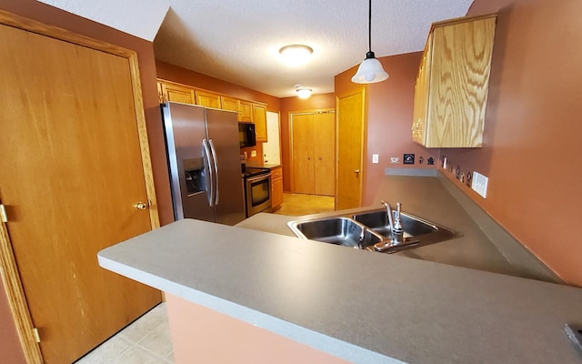 kitchen featuring sink, decorative light fixtures, a textured ceiling, kitchen peninsula, and appliances with stainless steel finishes