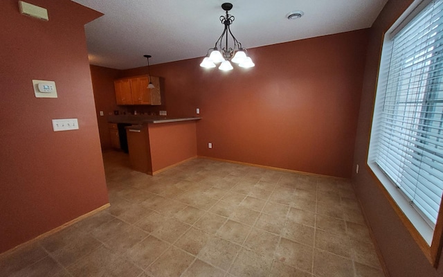 kitchen with decorative light fixtures, an inviting chandelier, and kitchen peninsula