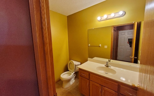 bathroom with a textured ceiling, vanity, and toilet