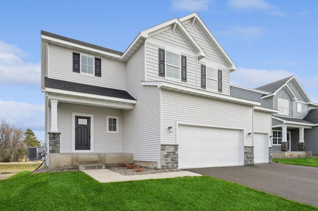 craftsman-style house featuring a front yard, a garage, and central AC unit