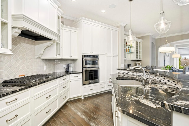 kitchen with appliances with stainless steel finishes, dark stone counters, sink, decorative light fixtures, and dark hardwood / wood-style floors